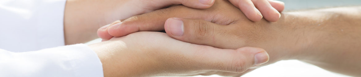 Two people holding hands for comfort